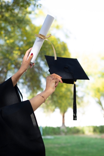 Manos sosteniendo Titulo y birrete