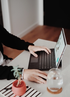 Laptop en mesa, con manos tecleando